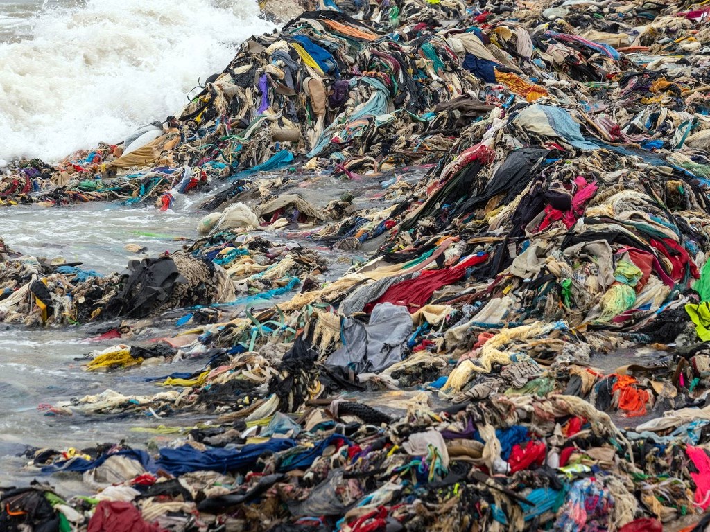 Pile of clothes washed up on a beach in Ghana