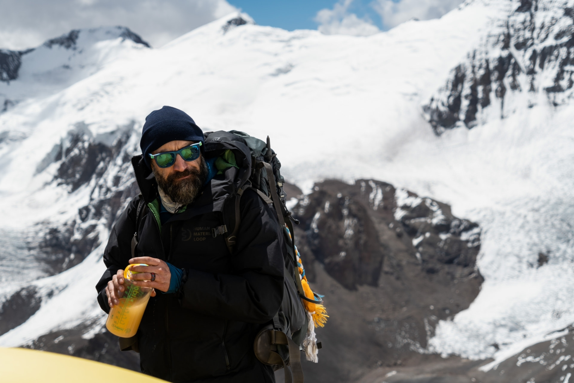 Leonardo Avezzano standing on the heights of Mount Aconcagua wearing the jacket made by Human Material Loop